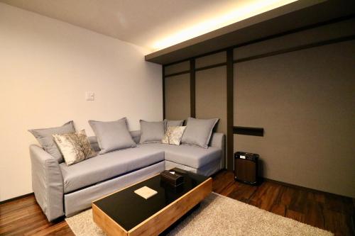 a living room with a couch and a table at One's Villa Sapporo in Sapporo