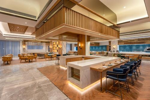 a lobby with a bar and tables and chairs at Radisson Resort Khopoli in Khopoli