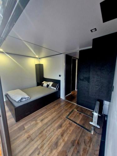 a bedroom with a bed and a wooden floor at Bright Room Houseboat in Belgrade
