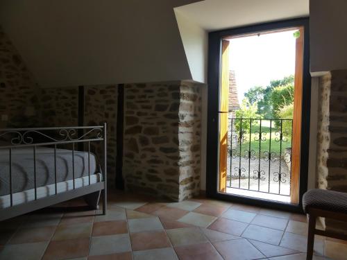 une chambre avec un lit et une porte coulissante en verre dans l'établissement La Maison de Louise, à Altillac