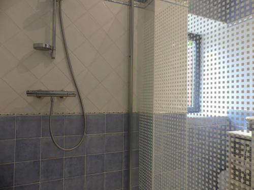 une douche avec une porte vitrée dans une salle de bain dans l'établissement La Maison de Louise, à Altillac