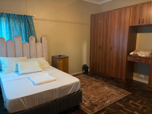 a bedroom with a large bed with a large headboard at RMK Guest house Zeerust in Zeerust