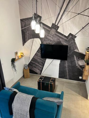 - un salon avec un canapé bleu et une fresque murale dans l'établissement Charming Duplex - Agen Centre, à Agen
