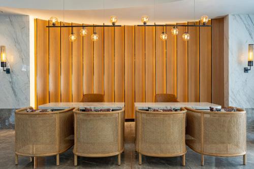 a dining room with two tables and wicker chairs at Radisson Resort Khopoli in Khopoli