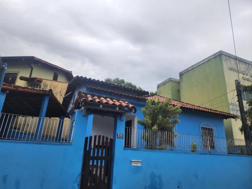 ein blaues Gebäude mit einem Tor und einem Zaun in der Unterkunft Casa no coração de Maricá in Maricá