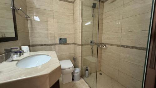 a bathroom with a shower and a sink and a toilet at Perfect Home Away from Home 3 BR - Maids in Ras al Khaimah