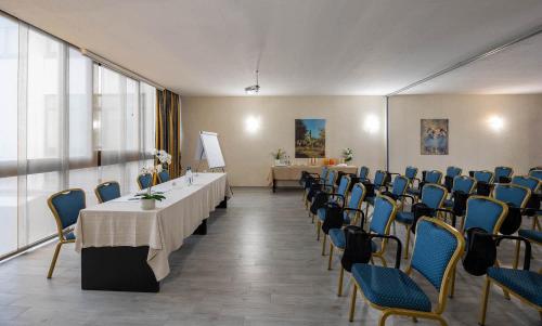 a conference room with tables and chairs and a table and chairs at iH Hotels Milano Eur - Trezzano sul Naviglio in Trezzano sul Naviglio