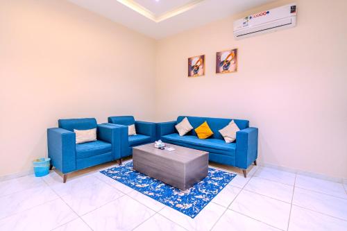 a living room with a blue couch and a table at شقة خاصة مؤثثة بالكامل للتأجير اليومي in Hafr Al Baten
