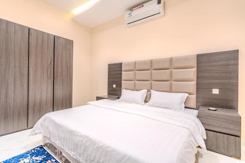 a bedroom with a large bed with a large headboard at شقة خاصة مؤثثة بالكامل للتأجير اليومي in Hafr Al Baten