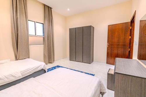 a bedroom with two beds and a cabinet in it at شقة خاصة مؤثثة بالكامل للتأجير اليومي in Hafr Al Baten