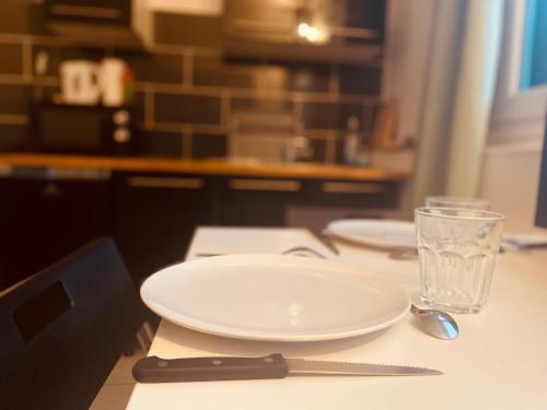 une assiette avec un couteau et un verre sur une table dans l'établissement Petit joyau urbain à Rouen - 358, à Rouen