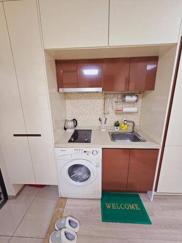 a small kitchen with a washing machine and a sink at Incheon City Hall Station Full Option Lovely House in Incheon