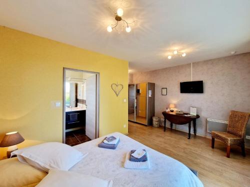a bedroom with a bed and a desk and a room at LES JARDINS DE LA GRANGE in Rezonville