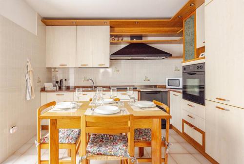 a kitchen with a wooden table and chairs with glasses at Casa al Vicolo [vicino al Lago di Garda] in Cavedine