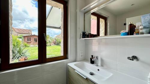 a bathroom with a sink and a window at Maison de ville cosy in Bergerac