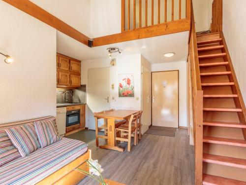 Il comprend un salon avec un escalier et une cuisine avec une table. dans l'établissement Appartement 6 pers, vue montagne, ski aux pieds, WIFI, animaux admis, Plagne Soleil - FR-1-351-3, à Plagne Villages