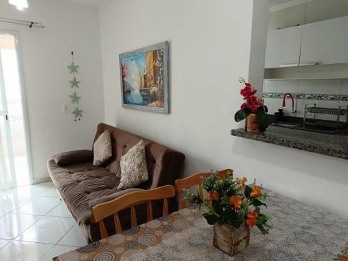 a living room with a couch and a table at Apê Temporada II Praia Grande SP Completo com Piscina, Churrasqueira, Estacionamento in Praia Grande