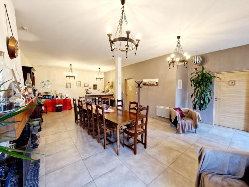 a dining room and living room with a table and chairs at LES JARDINS DE LA GRANGE in Rezonville