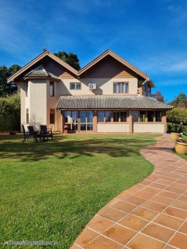 a house with a large yard with a pathway at Pousada Bliss House - Opções de suites com hidromassagem in Campos do Jordão