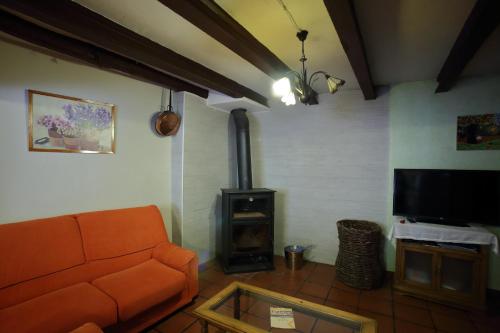 a living room with a couch and a wood stove at Casa Rural La Tejada in Alcalá de Moncayo
