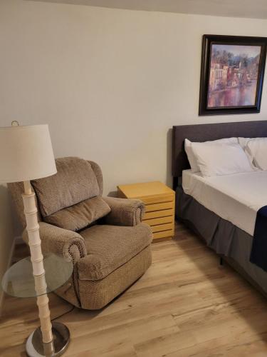 a bedroom with a chair and a bed and a lamp at The Link Vintage Motel #8 in Lovelock