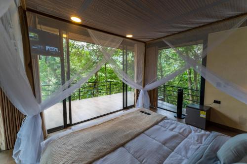 a bedroom with a bed and a large window at Rincon de la Sierra Minca in Minca