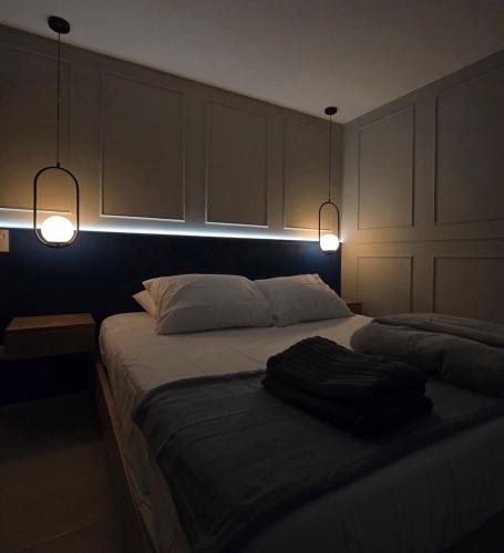 a bedroom with a bed with two lights on it at Casa Martín in Envigado