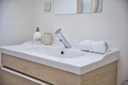 La salle de bains est pourvue d'un lavabo, d'un robinet et de serviettes. dans l'établissement Rare Perle - Studio, à Reims
