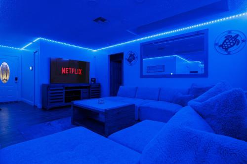a living room with a couch and a tv at Beach Villa Private pool fire pit 6mi to beach in Pinellas Park