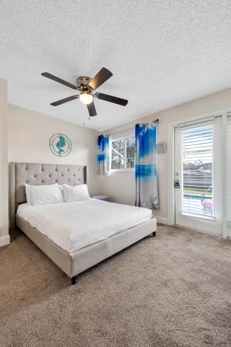 a bedroom with a bed and a ceiling fan at Beach Villa Private pool fire pit 6mi to beach in Pinellas Park