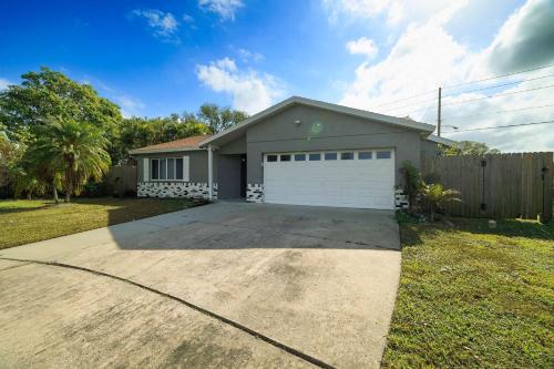 a small house with a white garage at Beach Villa Private pool fire pit 6mi to beach in Pinellas Park