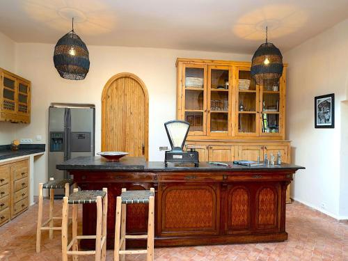 a kitchen with a large wooden island with bar stools at Palais Amon in Aït Imouni