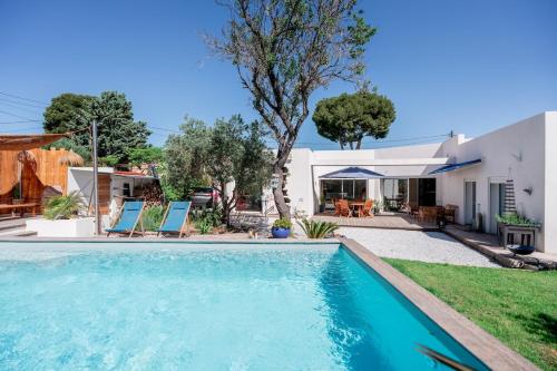 une piscine devant une maison dans l'établissement Villa Sormiou avec piscine, à Marseille
