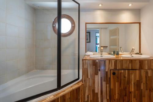 une salle de bain avec deux lavabos et une baignoire dans l'établissement Villa Sormiou avec piscine, à Marseille