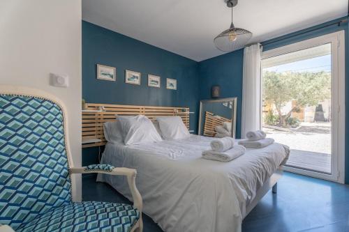 une chambre avec un lit, une chaise et une fenêtre dans l'établissement Villa Sormiou avec piscine, à Marseille