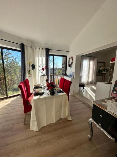 un salon avec une table et des chaises rouges dans l'établissement la maison de l'artiste, à Tourrettes-sur-Loup