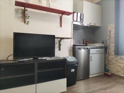 une cuisine avec une télévision à écran plat sur un comptoir dans l'établissement studio idéal visite de Paris, à Ivry-sur-Seine