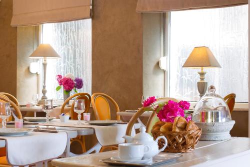 a dining room with tables and chairs with flowers on them at Hôtel Le Roosevelt in Givet