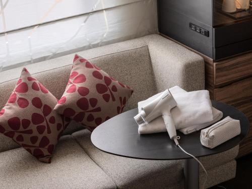 a living room with a couch with pillows and a table at Mitsui Garden Hotel Sapporo in Sapporo