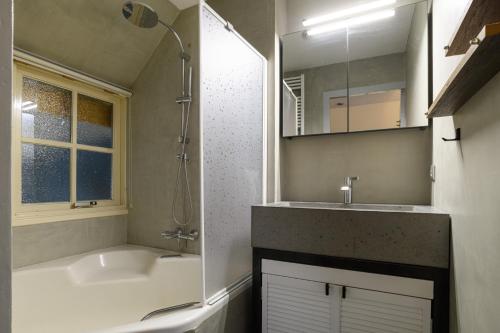a bathroom with a tub and a sink and a mirror at Summio Vakantiepark Herperduin in Herpen
