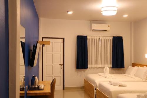 a hotel room with two beds and a window at Moya Boutique Hotel in Betong