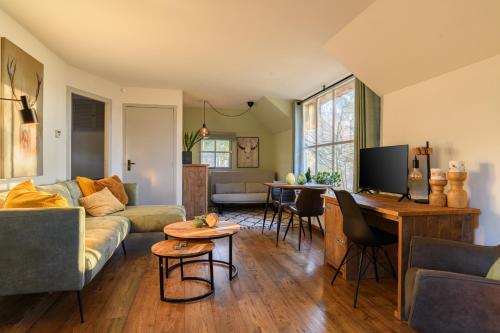 a living room with a couch and a table at Summio Vakantiepark Herperduin in Herpen