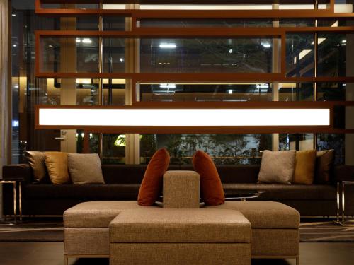 a room with couches and a chair with shoes on it at Mitsui Garden Hotel Sapporo in Sapporo