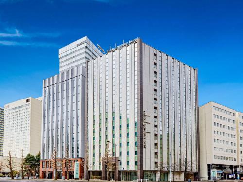 a tall white building with many windows at Mitsui Garden Hotel Sapporo in Sapporo