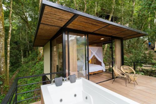 a house in the woods with a bath tub on a deck at Rincon de la Sierra Minca in Minca