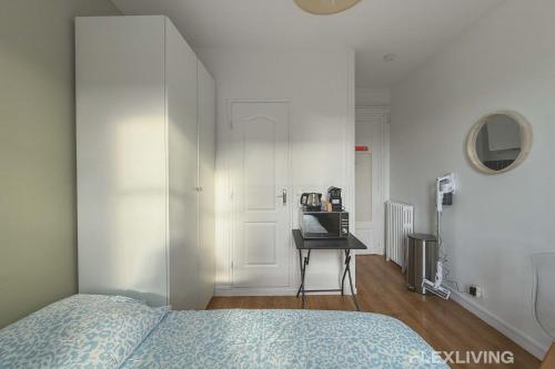une chambre avec un lit et une table avec un ordinateur portable dans l'établissement Flexliving - Studio - 27 Brune, à Paris