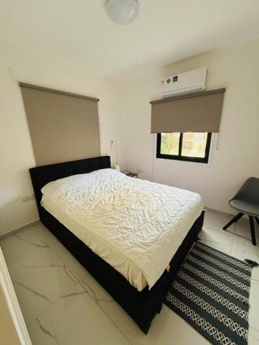 a bedroom with a bed and a window at Brand new, Finikoudes area in Larnaka