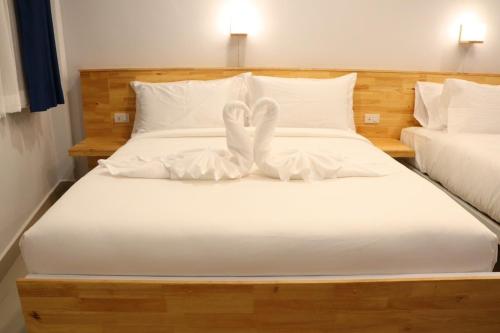 a white bed with a heart made out of pillows at Moya Boutique Hotel in Betong