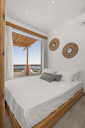 ein Schlafzimmer mit einem großen Bett und einem Fenster in der Unterkunft Ammos stegna in Archangelos