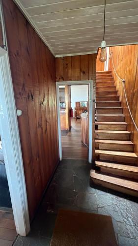 a stairway leading to a room with wooden walls at Hosteria CASA MILLER B&B FRENTE AL MAR in Bahía Mansa